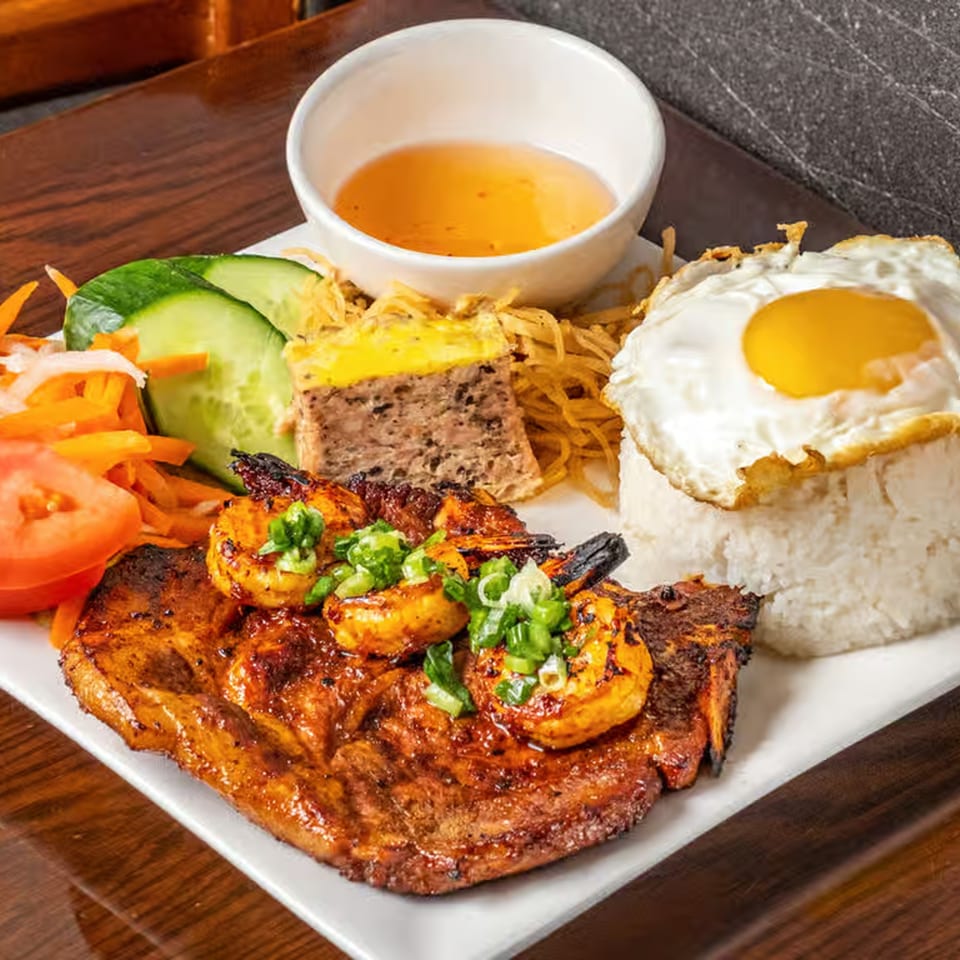 Anise Viet Cuisine's grilled pork chop and shrimp with rice, fried egg, and vegetables.