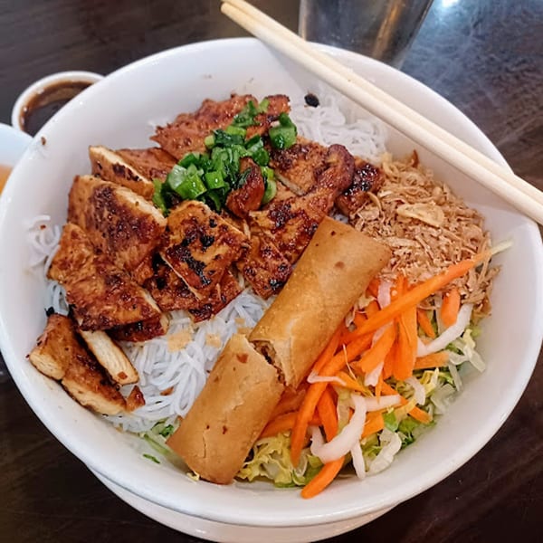 Anise Viet Cuisine's vermicelli bowl with grilled chicken, egg rolls, and fresh vegetables.